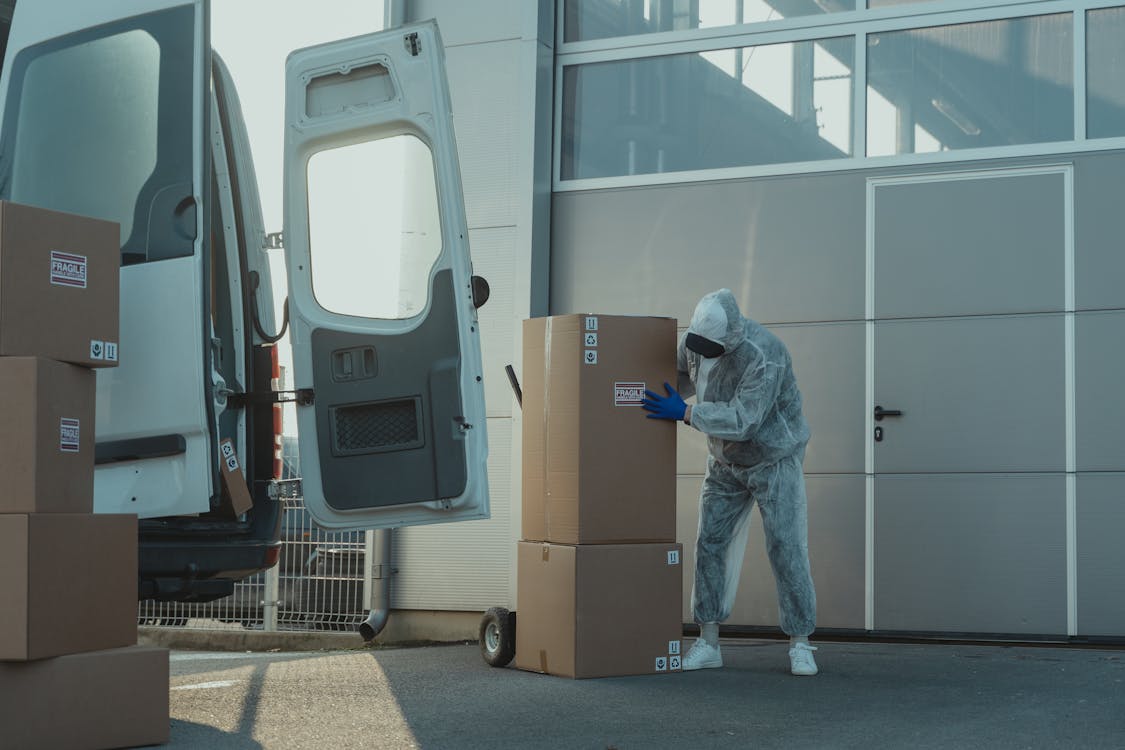 A Person Wearing Personal Protective Equipment in Handling Packages