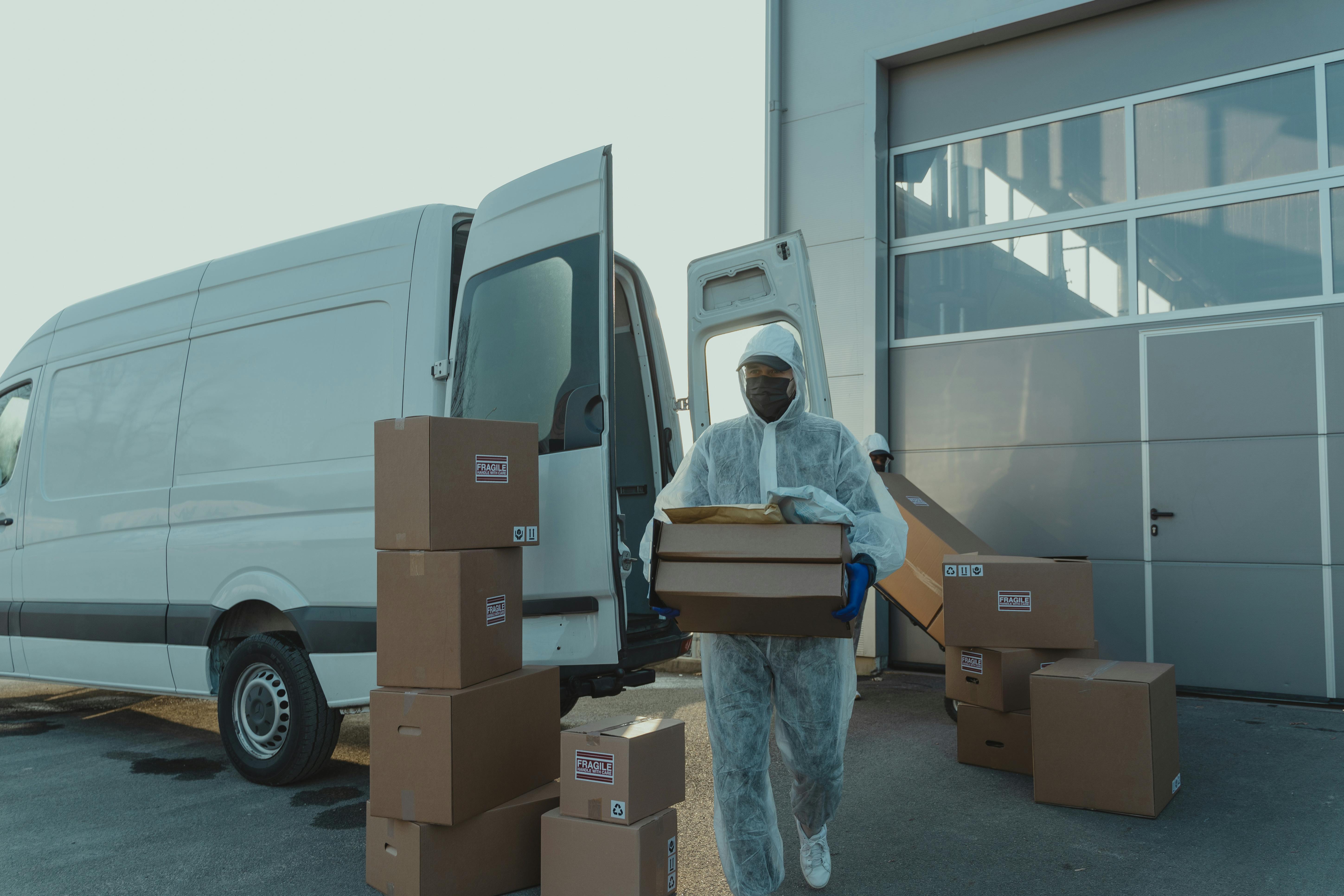 delivery man in ppe carrying a box