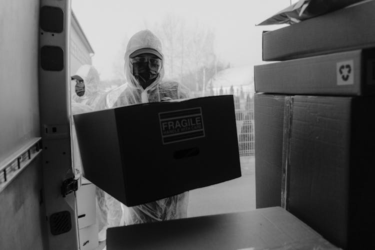 Delivery Men In PPE Delivering Boxes