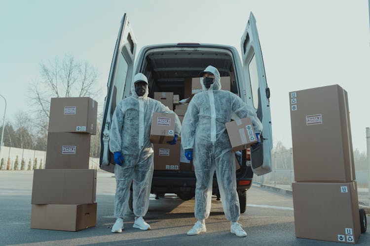 Delivery Men In PPE Holding Boxes