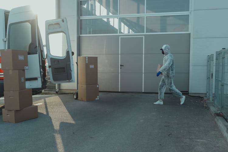 Delivery Man In PPE Going Towards A Van 