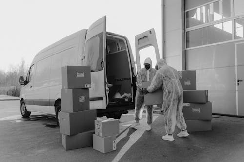 Free Delivery Men in PPE carrying a Package  Stock Photo