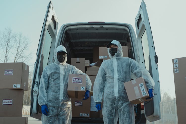 Delivery Men In PPE Carrying BOxes