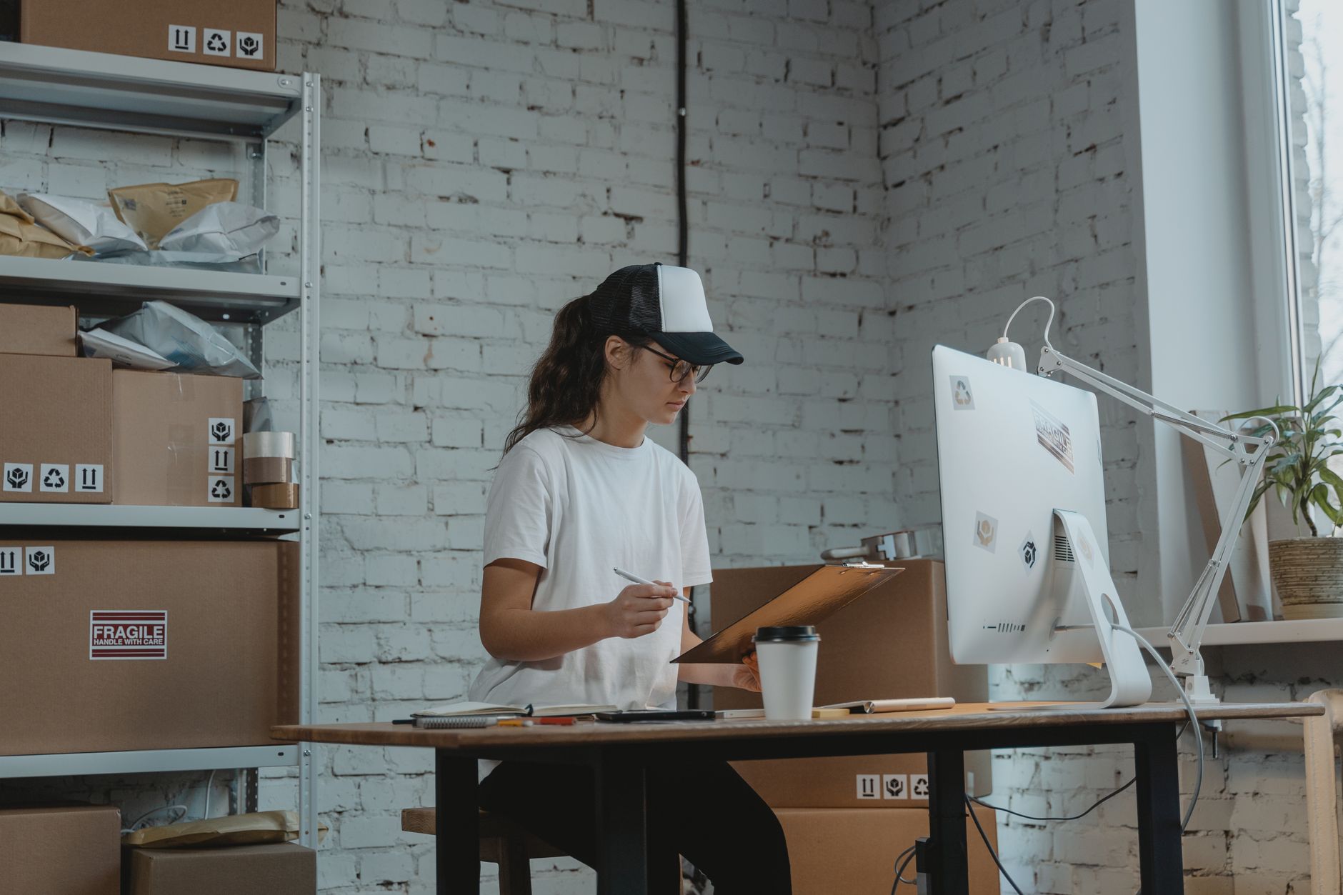 Woman focused on logistics management in a modern office environment, showcasing organization and efficiency.