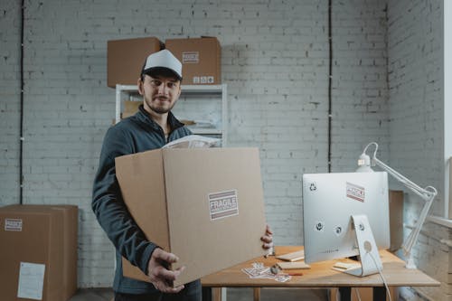 Man in Jacket Holding Cardboard Box