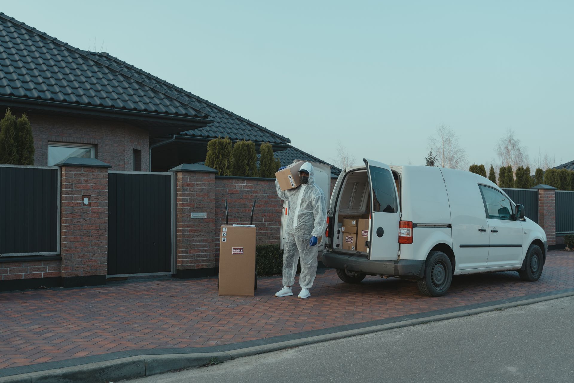 Delivery Man in PPE carrying a Box