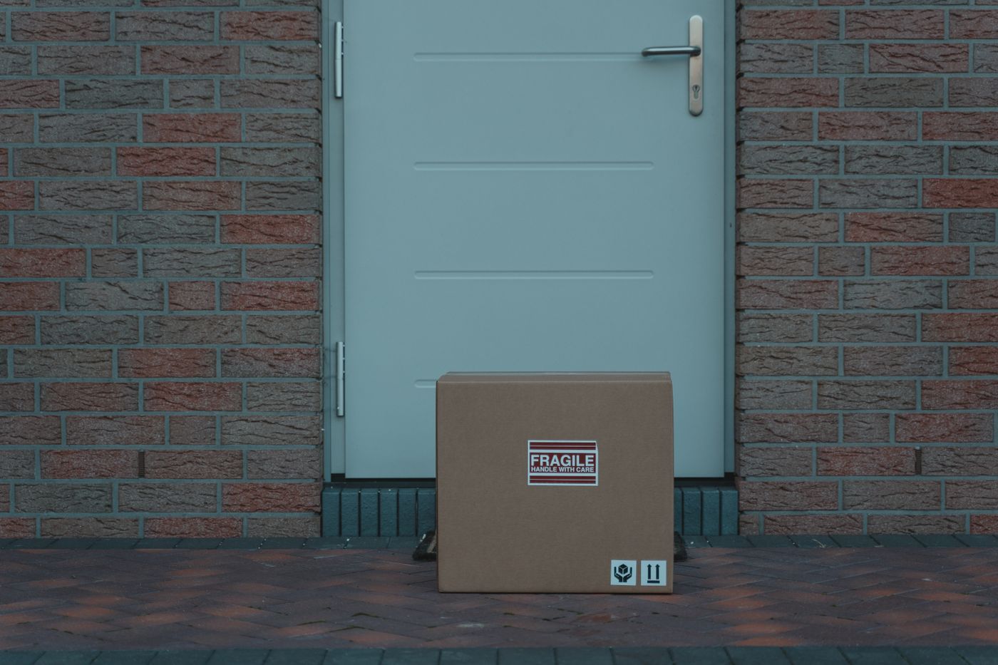 Delivered cardboard parcel marked fragile outside a residential doorway