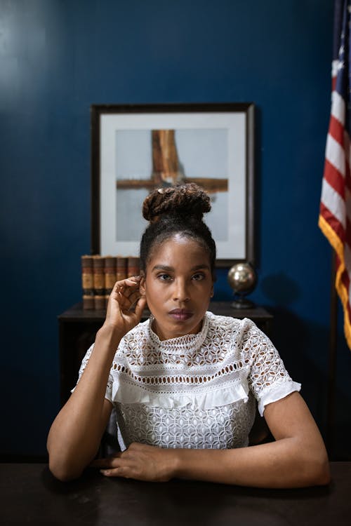 Professional Woman sitting beside a Wooden Table 