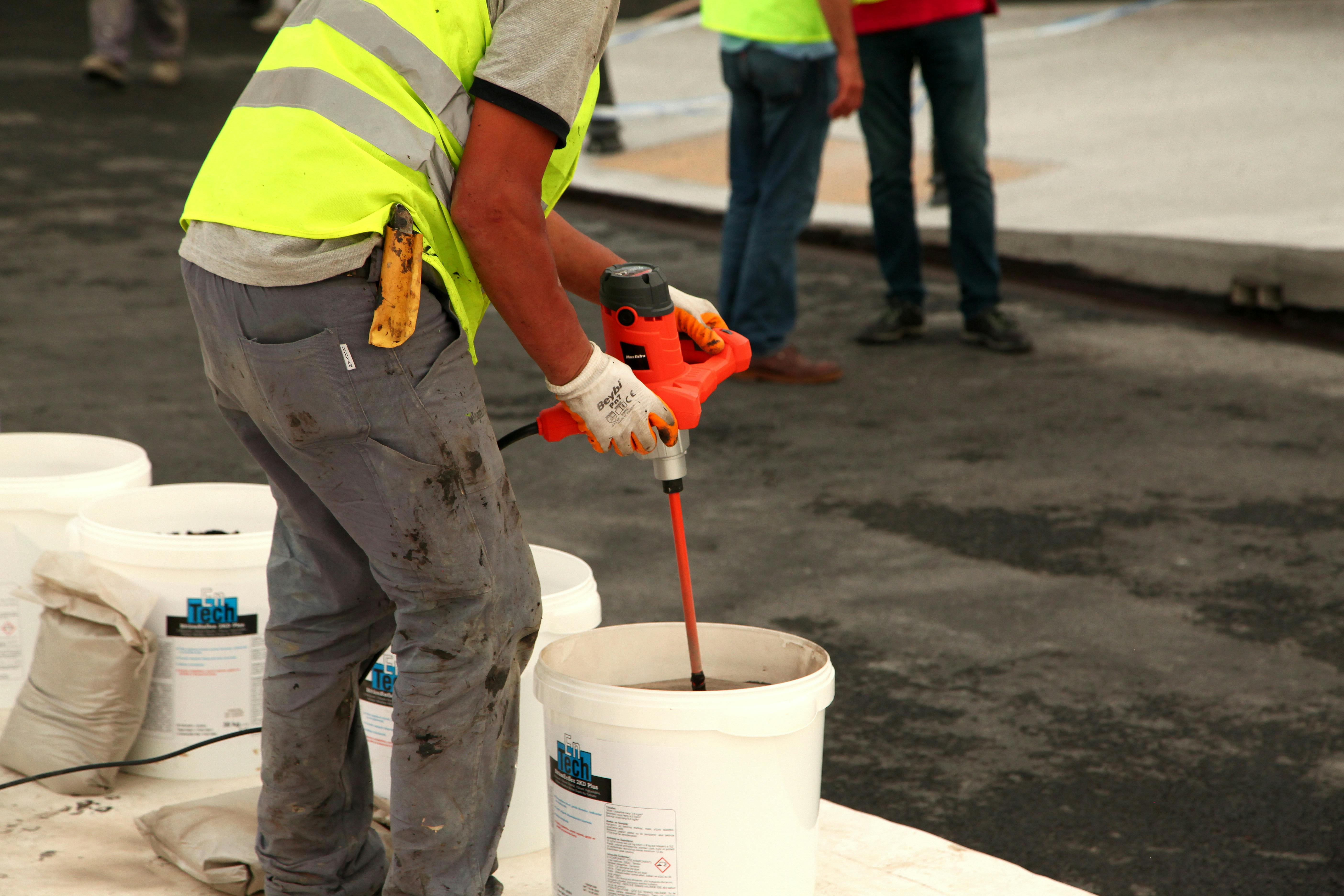 a man working and using a mud mixer