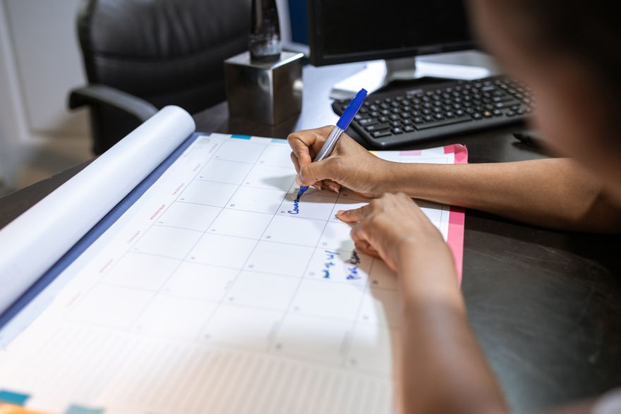 A wall planner covered in dated notes