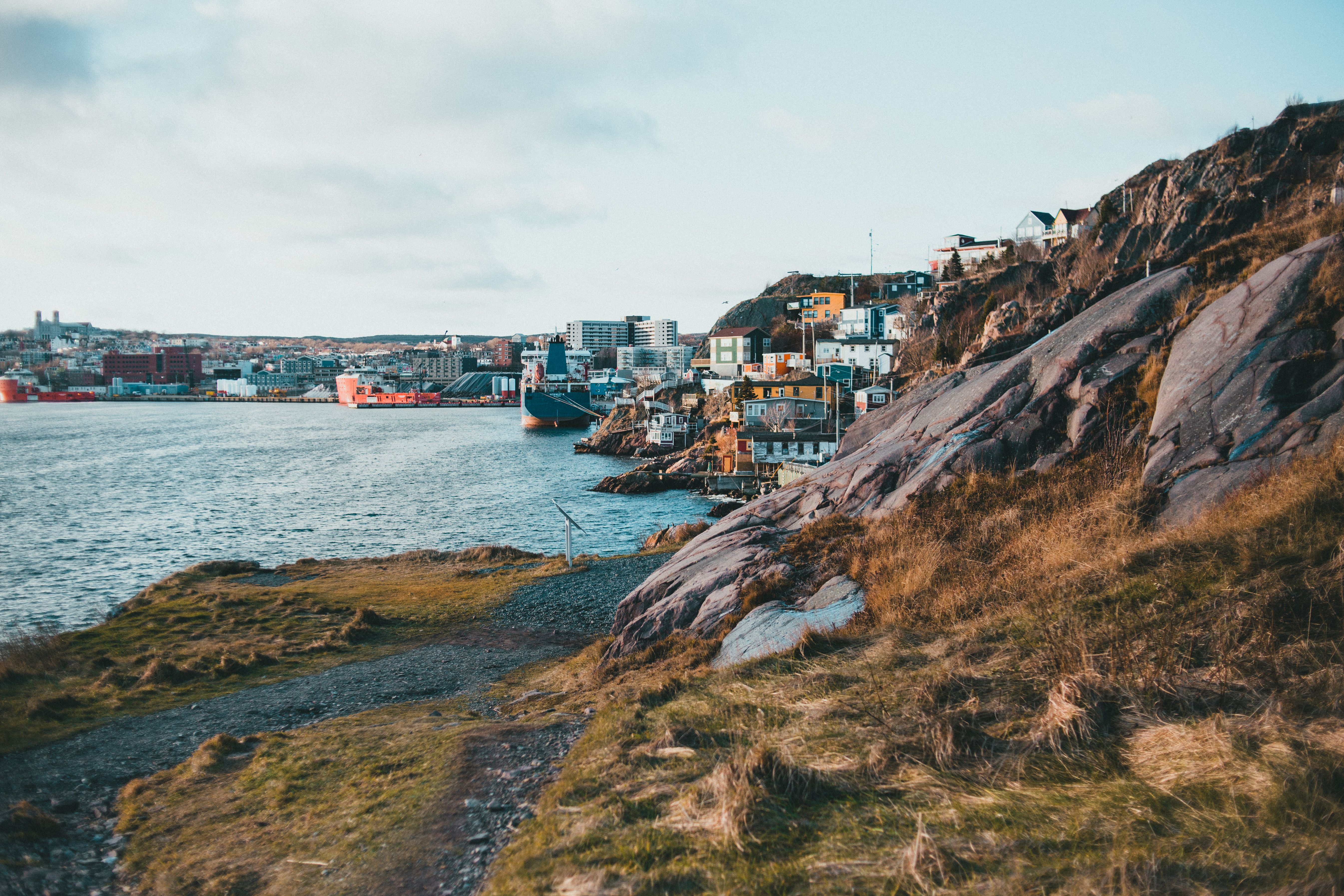 Scenic urban waterfront with rocky coastline and vibrant city.