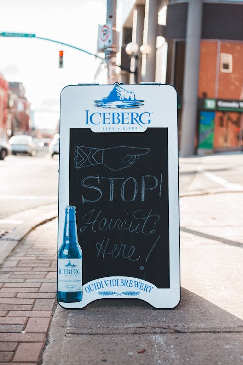 White and Black Board Signage on Sidewalk