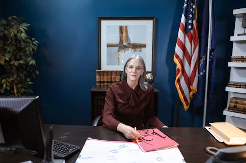 Professional Woman sitting beside a Wooden Table 