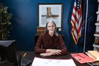 Professional Woman sitting beside a Wooden Table