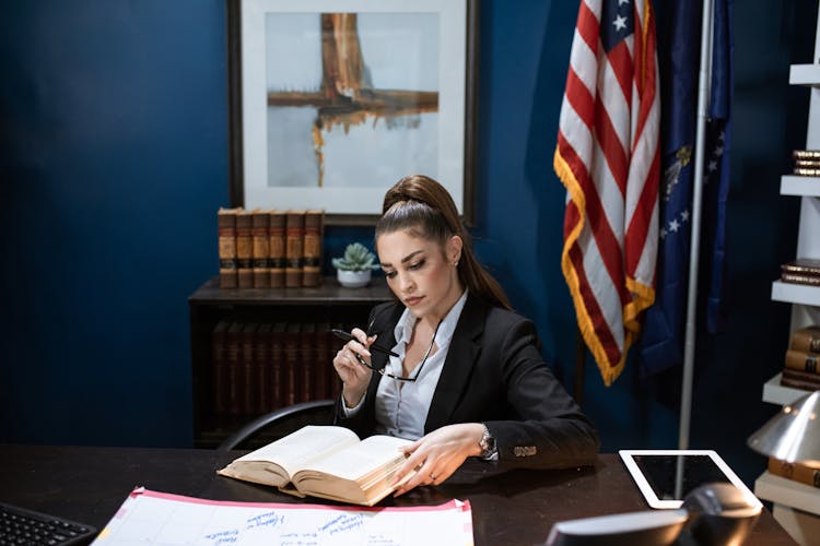 A Woman In Black Blazer Reading A Book