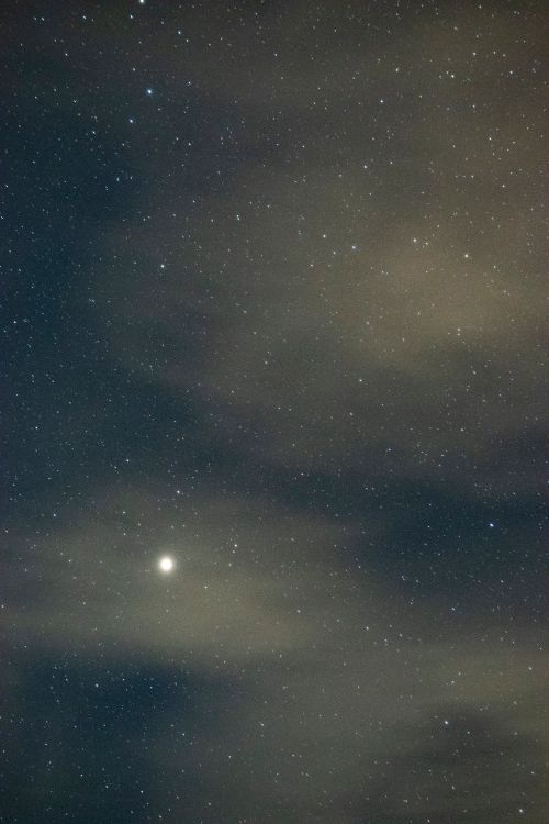 Free A serene view of a starry night sky partially obscured by clouds, captured in Algeria. Stock Photo