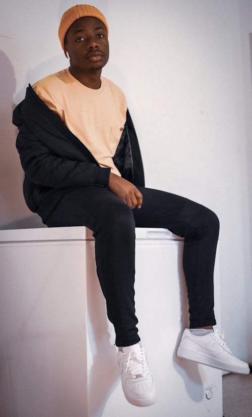 Man in Black Jacket and Pants sitting on Top of White Surface 