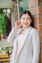 Elegant Woman in Formal Blazer leaning on a Brick Column