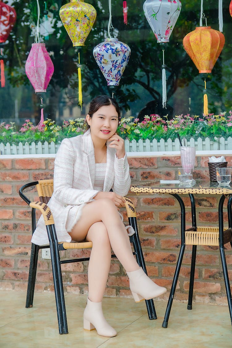 Elegant Woman In Formal Wear Sitting On A Woven Chair 