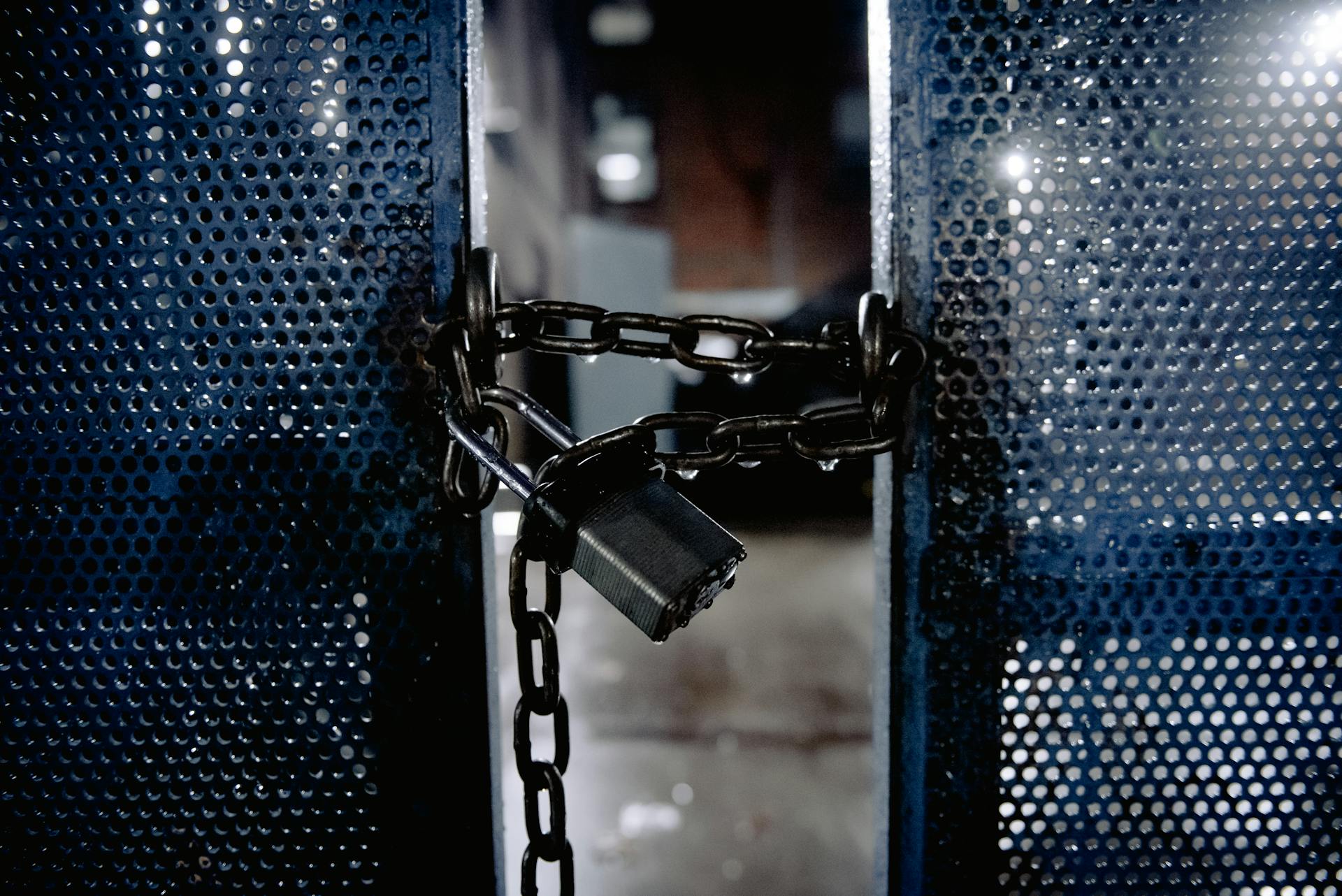 Metal lock on blue gates on entrance of building