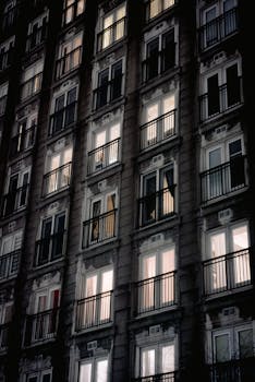 Night view of a dimly lit residential building with glowing windows showcasing urban nightlife.