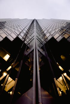 Upward view of a modern skyscraper with a geometric facade and sleek design.
