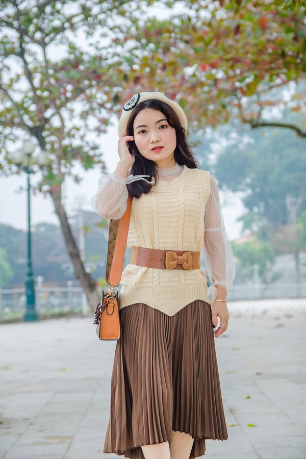 Woman wearing a pleated midi skirt with a knit top