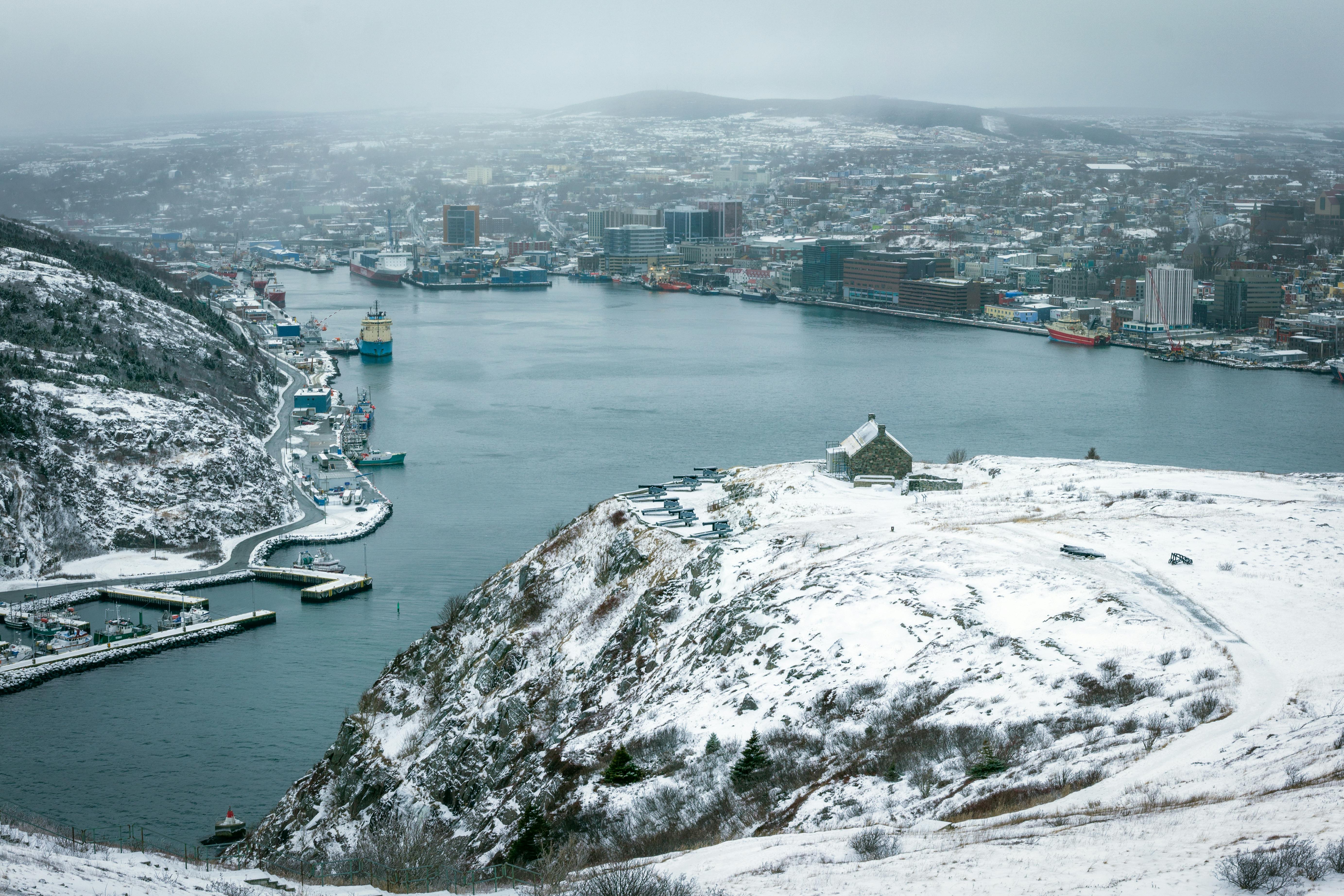 Snowy coastal town surrounded by hills under overcast sky · Free Stock(02)