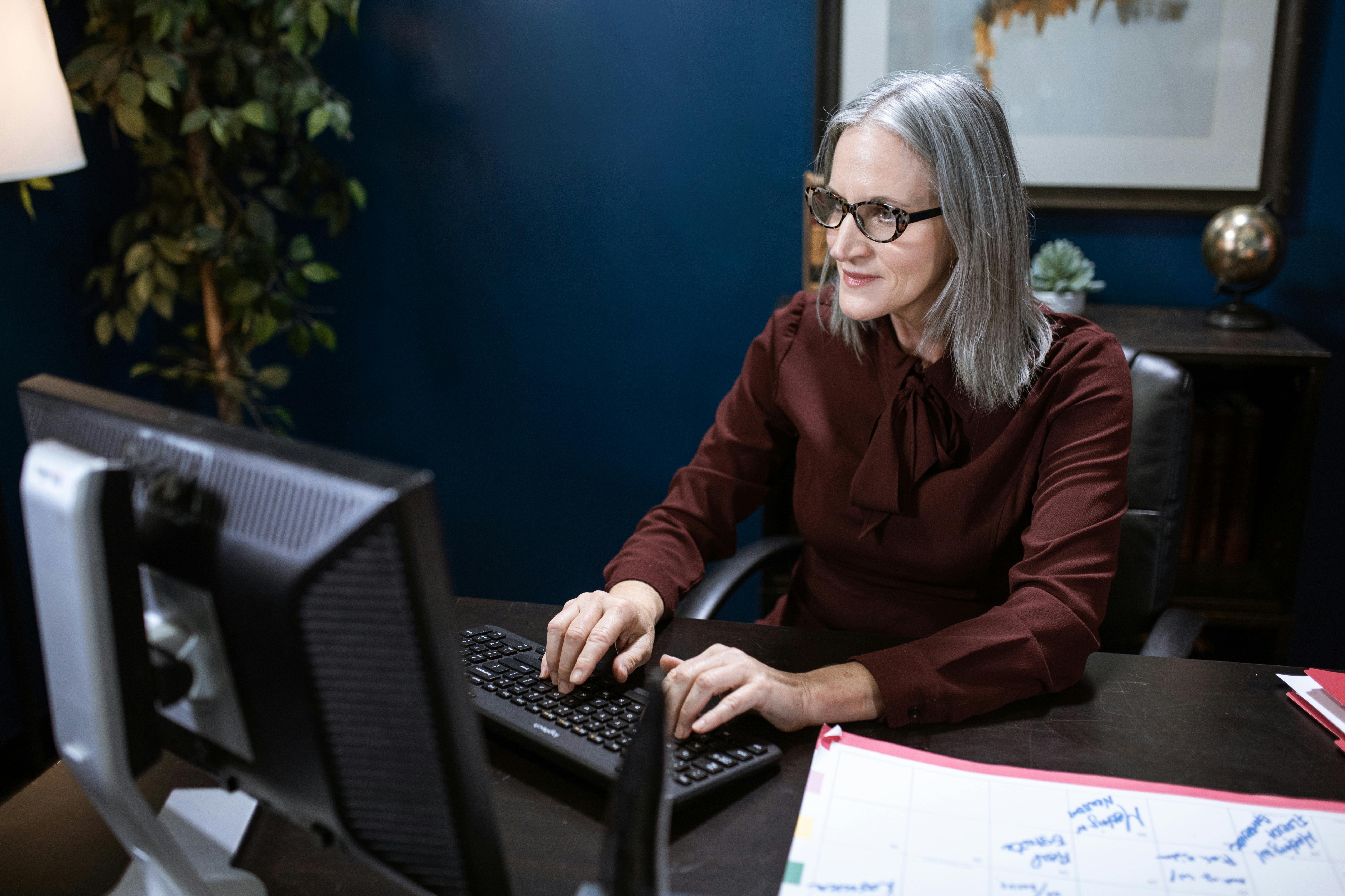 an elderly woman using a computer