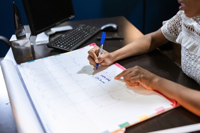 Hand writing notes in a desk calendar — photo by RDNE Stock project on Pexels