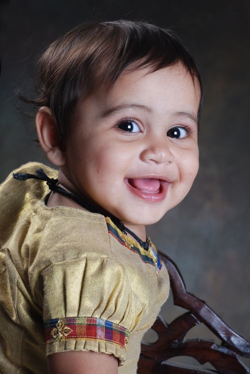 Free Charming baby portrait with a smile, wearing a colorful traditional dress. Stock Photo