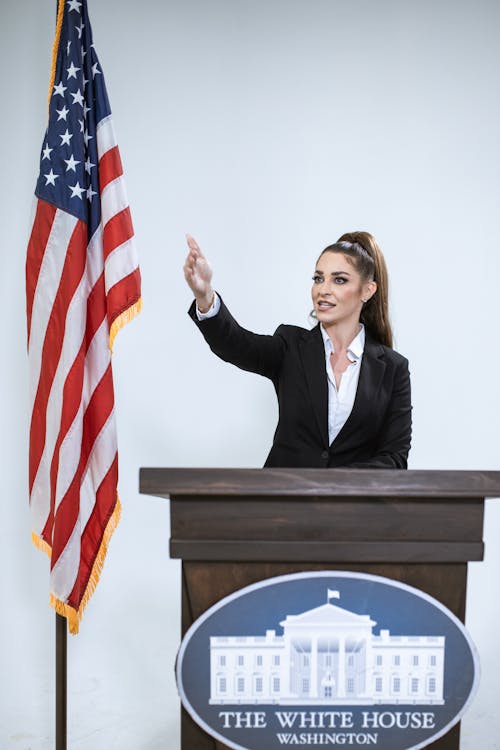 Free Woman In Black Blazer Holding Us A Flag Stock Photo