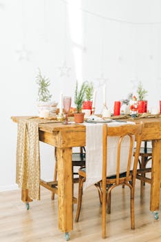 Beautifully decorated holiday dining table with festive elements and greenery indoors.