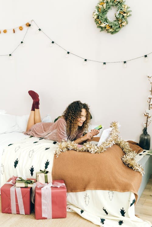 免費 躺在床上的棕色和白色禮服的女人 圖庫相片