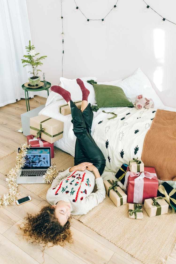 A Woman Lying Down With Christmas Presents