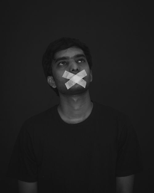 Free Black and white portrait of a man with mouth taped, symbolizing silence and restraint. Stock Photo
