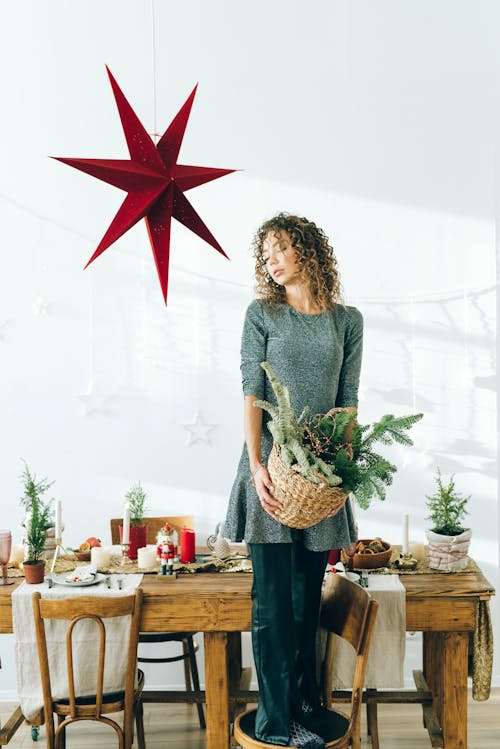 Woman in Green Dress Holding Green Plant