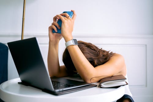 Woman in Black Tank Top Using Black Laptop Computer