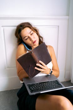 Stressed woman multitasking with laptop and phone, showcasing work-from-home fatigue.