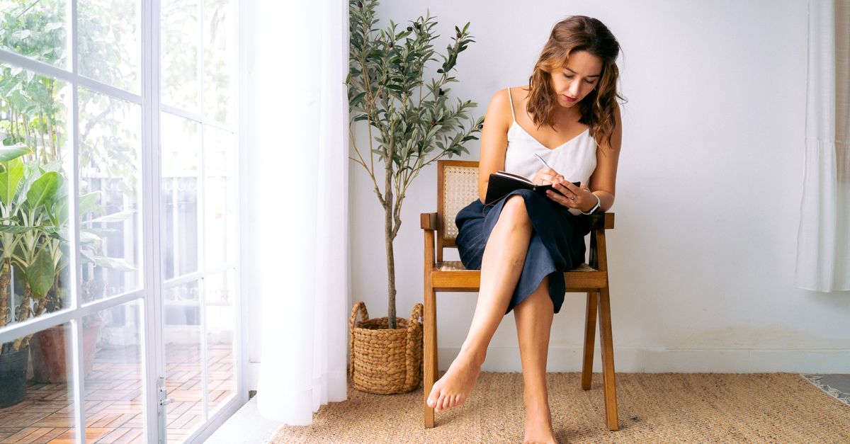 person journaling by window in quiet morning light