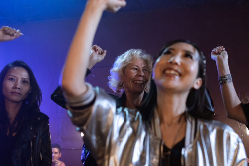 Free Group of diverse women enjoying a lively night at a club with music and dance. Stock Photo