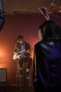 Man in Long Sleeves Playing Guitar While Sitting on Stool