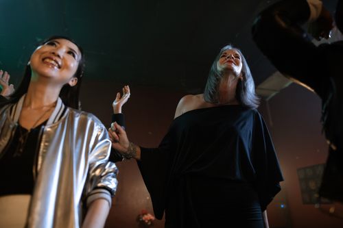 Free Joyful women dancing and smiling at a lively club during the night. Stock Photo