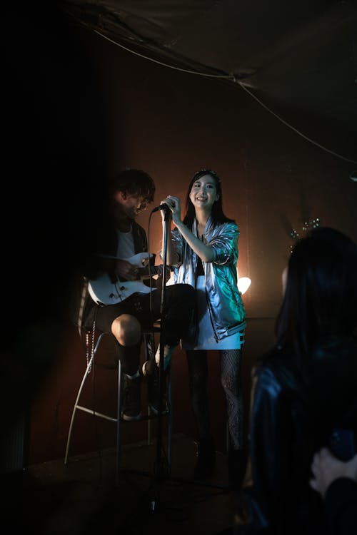 Man and Woman Singing on Stage