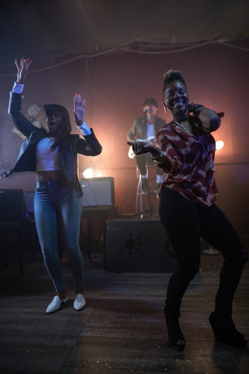 Two Women Dancing Along a Live Performance