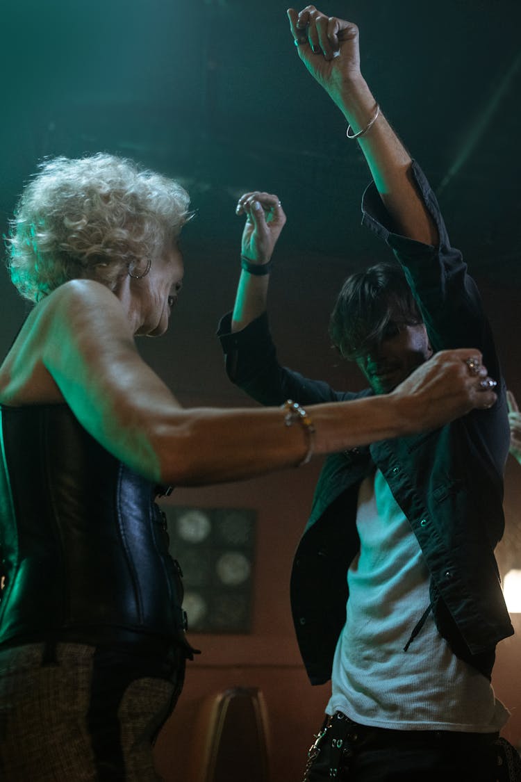 An Elderly Woman Dancing With A Man On A Nightclub