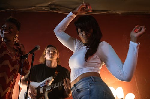 Frau Im Weißen Trägershirt Und In Den Blauen Jeansshorts, Die E Gitarre Halten