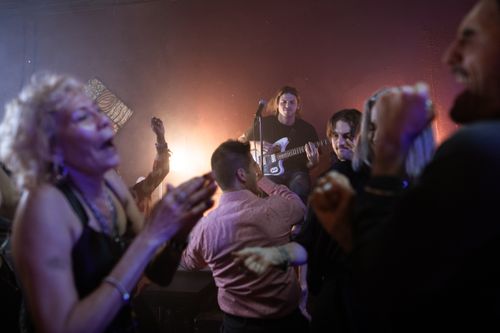 Free Vibrant party atmosphere with people enjoying live guitar music in a lively club setting. Stock Photo