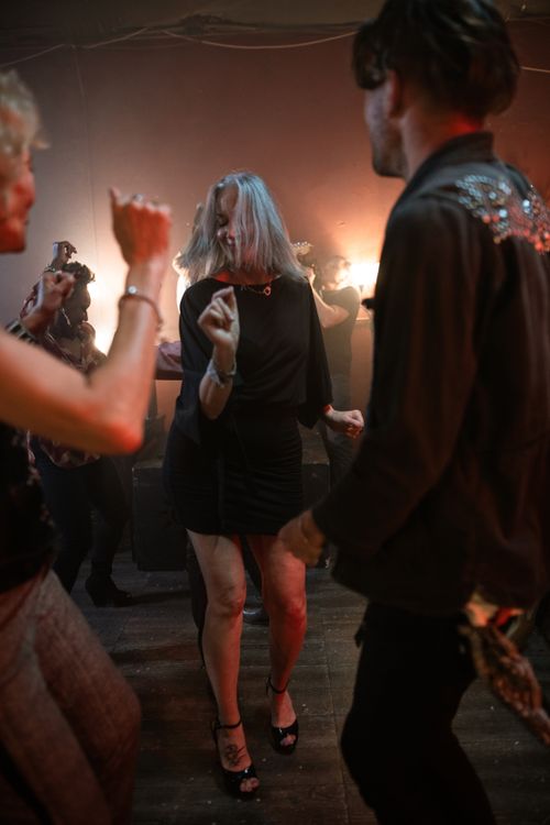 Free A lively group of adults dancing energetically at a nightclub party under warm lights. Stock Photo