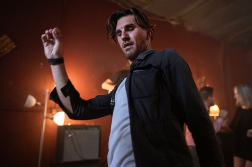 Free Energetic dancer in a dimly lit nightclub setting, expressing lively nightlife vibes. Stock Photo